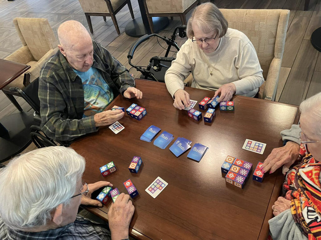 Seniors engaging in a game of the Uzzle at the senior living community.